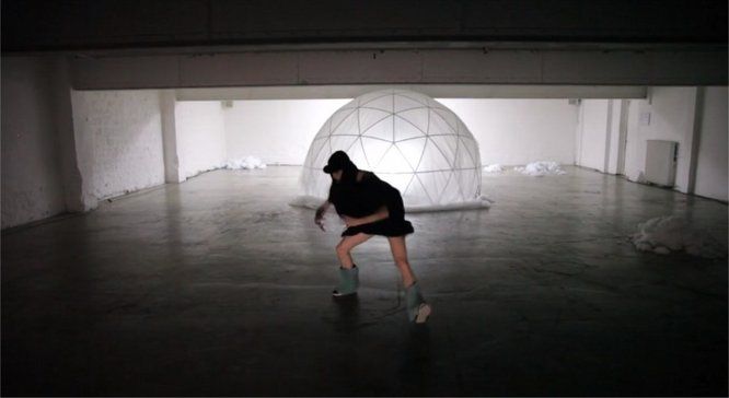 danseuse dansant habillée en noir, au second plan, une structure en forme d'igloo