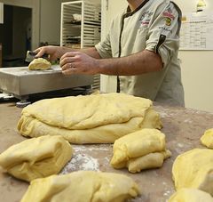 gros plan sur un boulanger travaillant sa pâte à pain