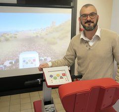 Benjamin Cosse, associé fondateur et PDG de Cottos Médical présente un fauteuil devant un écran de réalité virtuelle